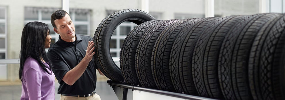 Subaru service representative showing customer a tire. | SubaruDemo3 in Salt Lake City UT
